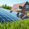 Zonnepanelen op een dak van een Nederlands huis met een groene tuin op de achtergrond.