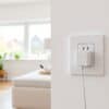 Wit stopcontact aan de muur in een Nederlandse woonkamer met een aangesloten oplader.