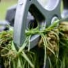 Grasmaaier verstopt met natte kluiten gras in een Nederlandse tuin.