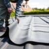 Dakdekker legt EPDM dakbedekking aan op een plat dak van een Nederlandse bakstenen woning.